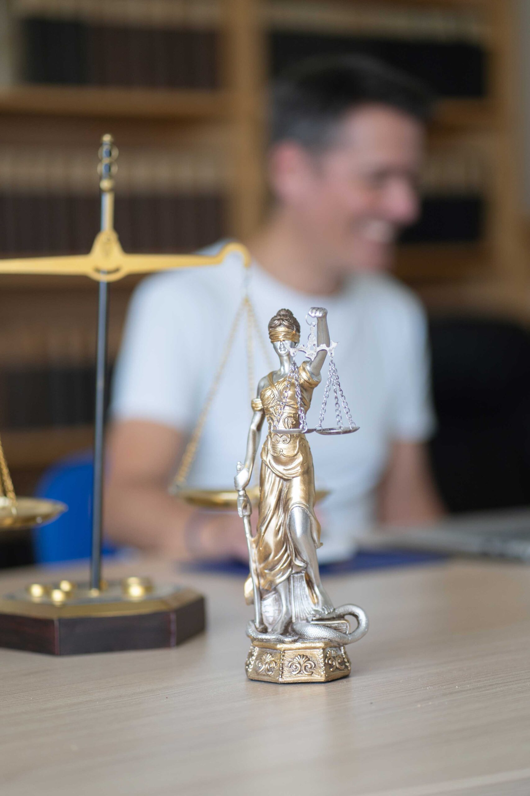 Themis Themisfigur steht klein auf dem Anwaltstisch