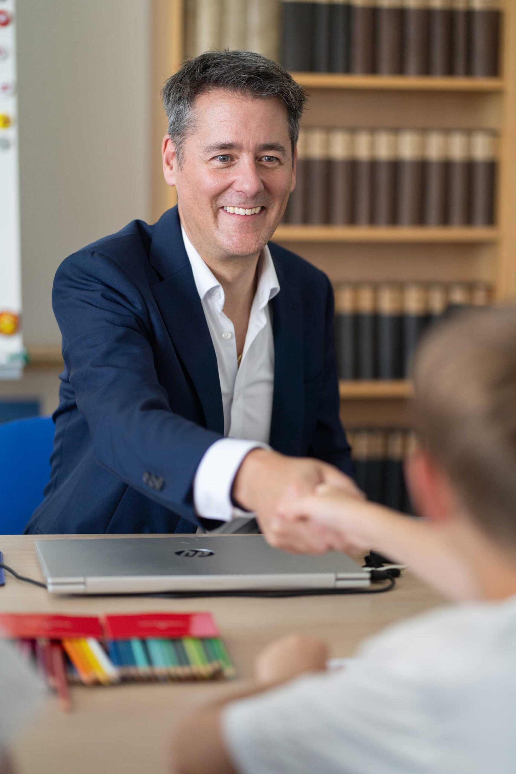 Kinderanwalt schüttelt Hand eines Kindes, er klärt ihn auf über sein Recht